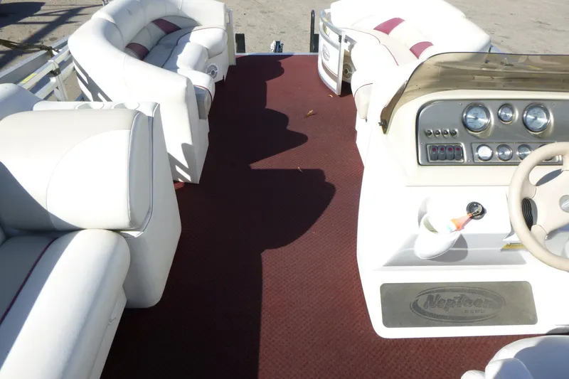 Slide: The Image of Interior of a 2004 J 21' Neptune boat with white seating and dashboard. - 4