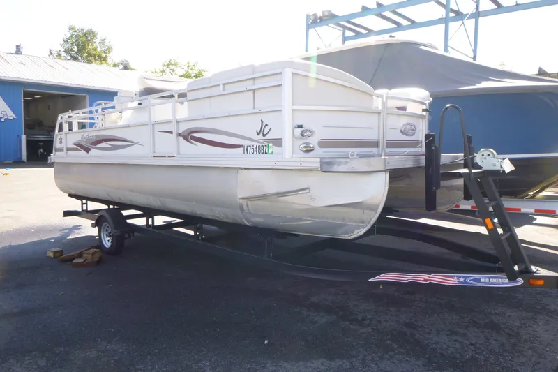 Slide: The Image of 2004 J 21' Neptune pontoon boat on trailer in outdoor setting. - 2