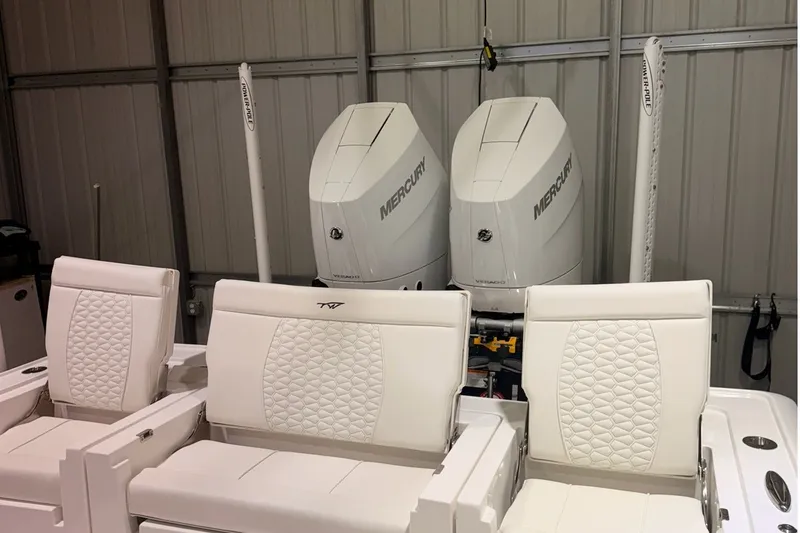 Slide: The Image of 2027 Tidewater 3100 Carolina Bay boat with dual Mercury engines in a garage. - 16