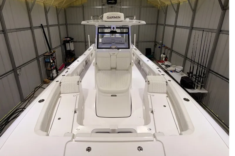 Slide: The Image of 2027 Tidewater 3100 Carolina Bay boat in a storage facility, featuring a sleek white interior. - 11