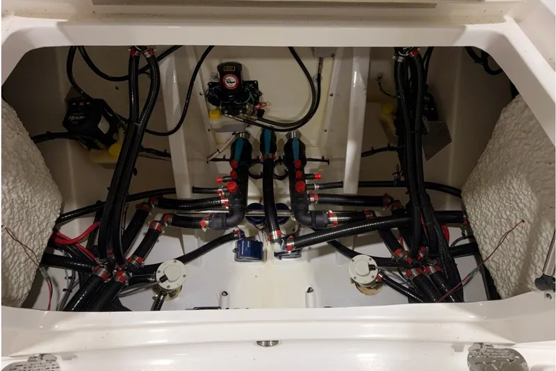 Slide: The Image of Engine compartment of 2027 Tidewater 3100 Carolina Bay boat, showcasing complex wiring and plumbing. - 15