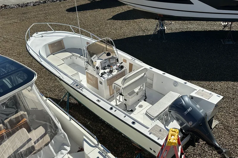 Slide: The Image of 1978 Mako 252 Center Console boat with Yamaha 300 engine, docked on gravel. - 1