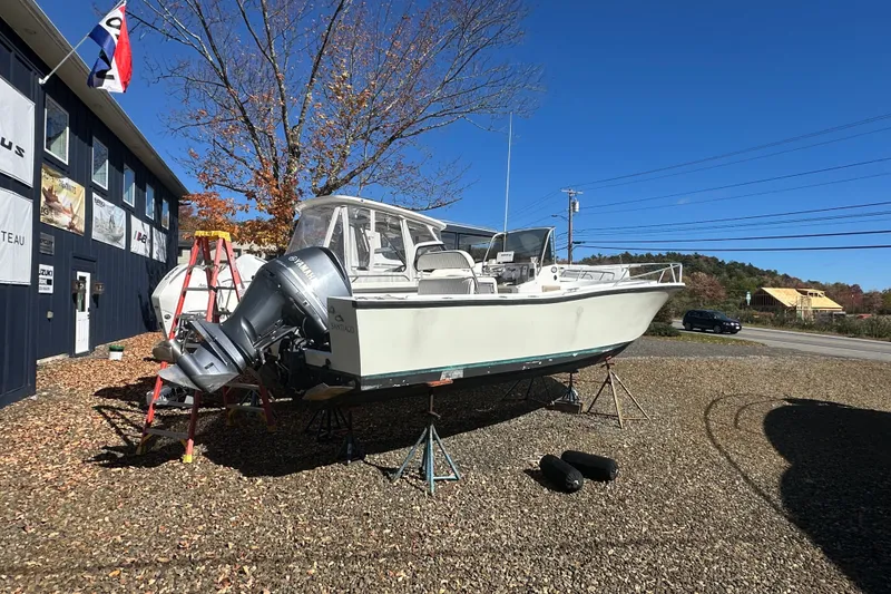 Slide: The Image of 1978 Mako 252 Center Console boat on stands, with Yamaha outboard motor, near a building. - 6