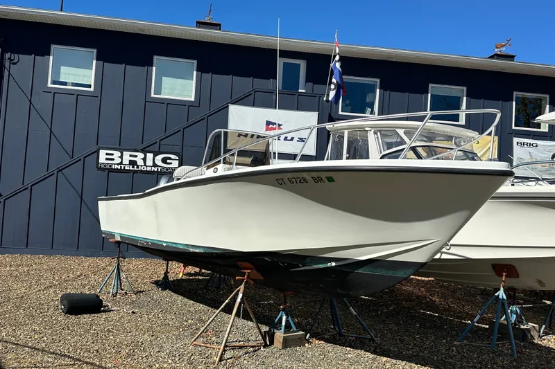 The Image of 1978 Mako 252 Center Console boat on stands outside a blue building. - 0