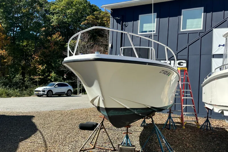 Slide: The Image of 1978 Mako 252 Center Console boat on stands, parked near a building and car. - 10