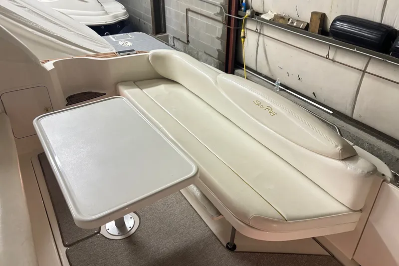 Slide: The Image of Interior seating area of 2000 Sea Ray 340 Sundancer with table and cushioned bench. - 6