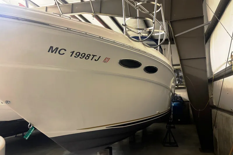 Slide: The Image of 2000 Sea Ray 340 Sundancer boat in storage, displaying registration number MC 1998TJ. - 2