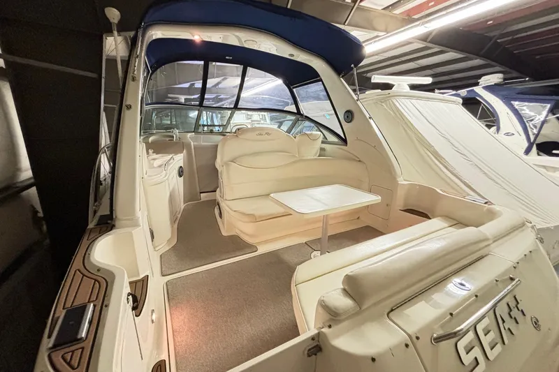 Slide: The Image of 2000 Sea Ray 340 Sundancer interior with white seating and table in a covered marina. - 5