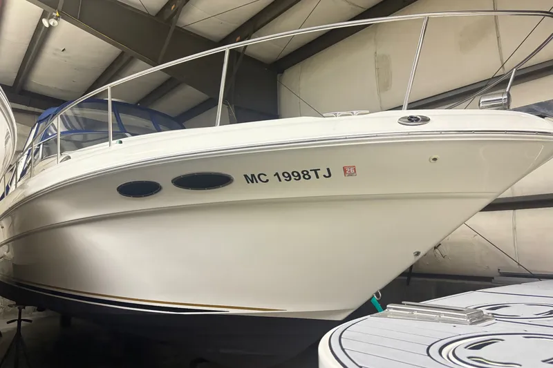 Slide: The Image of 2000 Sea Ray 340 Sundancer yacht in indoor storage, showcasing sleek design and registration number. - 1