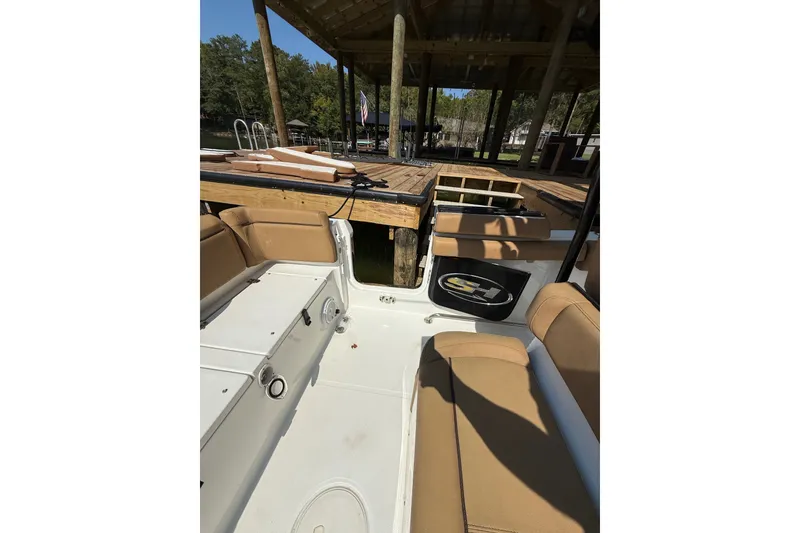 Slide: The Image of 2020 Sea Hunt Ultra 255SE boat interior with tan seating and dock view. - 13