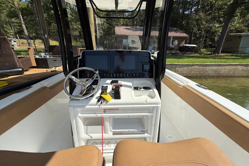 Slide: The Image of 2020 Sea Hunt Ultra 255SE boat cockpit with steering wheel and control panel. - 14