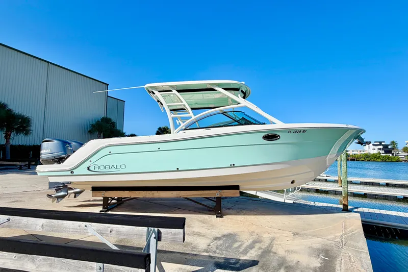 The Image of 2019 Robalo R317 Dual Console boat on dock, clear blue sky background. - 0