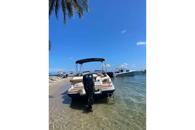 Slide: The Image of 2021 Bayliner VR6 Bowrider OB docked on a sunny beach with clear blue skies. - 6