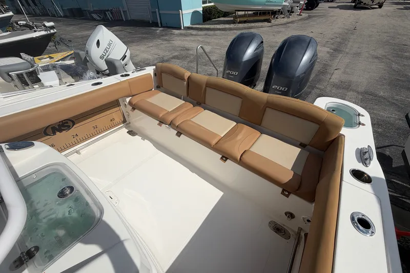 Slide: The Image of 2023 NauticStar 2602 Legacy boat interior with tan seating and dual engines. - 14