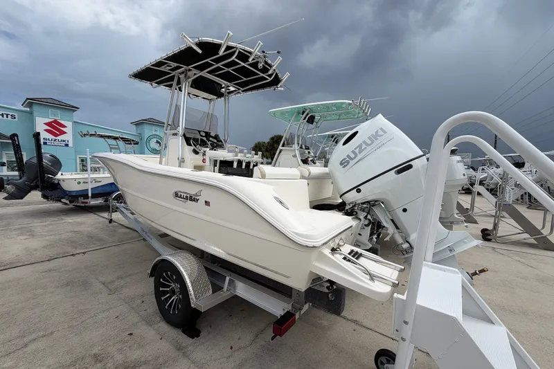 Slide: The Image of 2027 Bulls Bay 200 Center Console boat with Suzuki engine on trailer, under cloudy sky. - 4