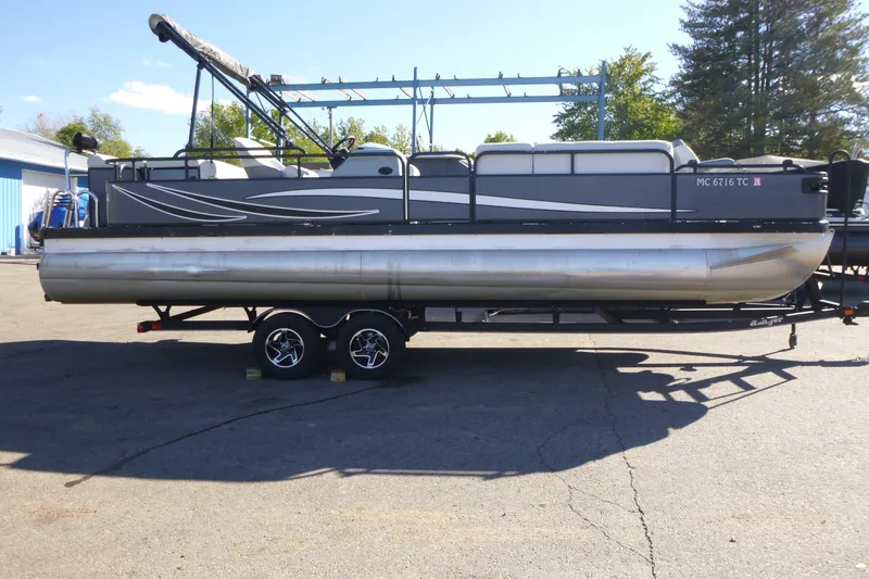 The Image of 2000 Bennington 2575 pontoon boat on trailer, parked outdoors on sunny day. - 0