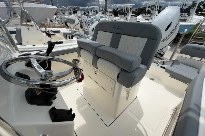 Slide: The Image of 2027 Pioneer 202 Sportfish boat interior with steering wheel and cushioned seating. - 12