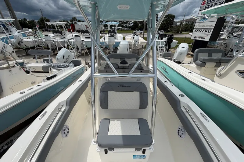 Slide: The Image of 2027 Pioneer 202 Sportfish boat interior with seating and console, surrounded by other boats. - 10