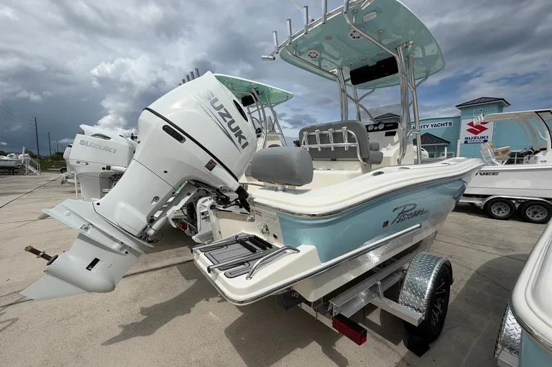 Slide: The Image of 2027 Pioneer 202 Sportfish boat with Suzuki outboard motor, parked on a trailer. - 2