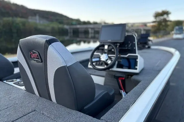 Slide: The Image of 2025 Ranger ALPHA 208 boat interior with steering wheel and modern dashboard by a river. - 30