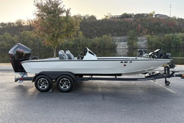 Slide: The Image of 2025 Ranger ALPHA 208 boat on trailer by a scenic lakeside. - 1
