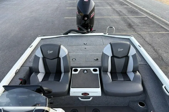 Slide: The Image of 2025 Ranger ALPHA 208 boat interior with dual seats and motor, parked on asphalt. - 47