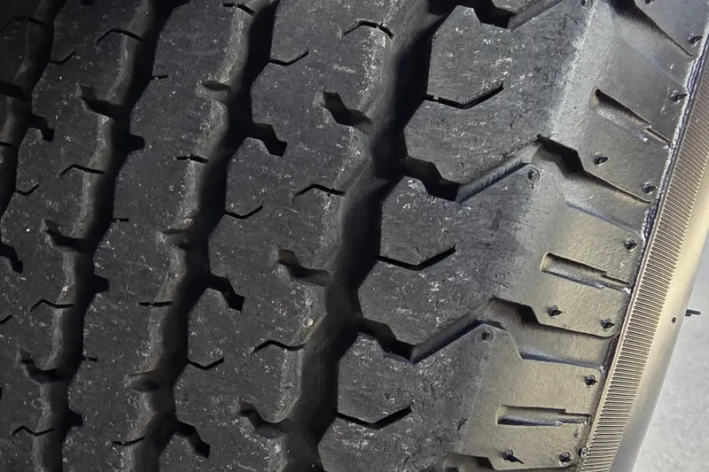 Slide: The Image of Close-up of Ranger ALPHA 208 tire tread, 2025 model, showcasing rugged design. - 39