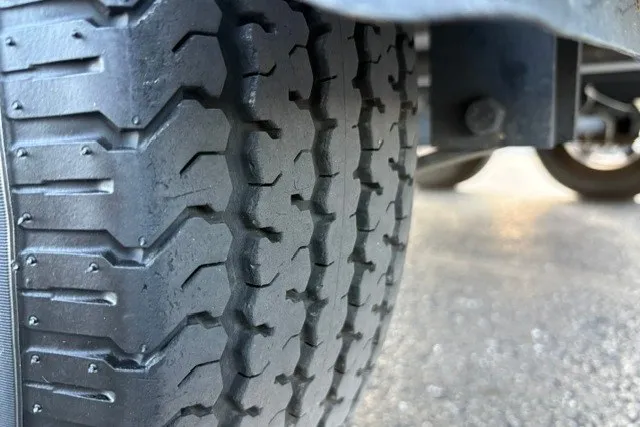 Slide: The Image of Close-up of Ranger ALPHA 208 tire tread, 2025 model, on asphalt surface. - 76
