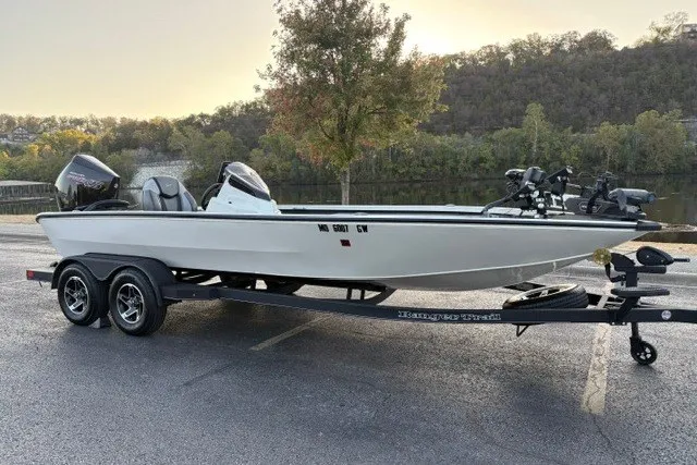 Slide: The Image of 2025 Ranger ALPHA 208 boat on trailer, parked near scenic lake and forest backdrop. - 3