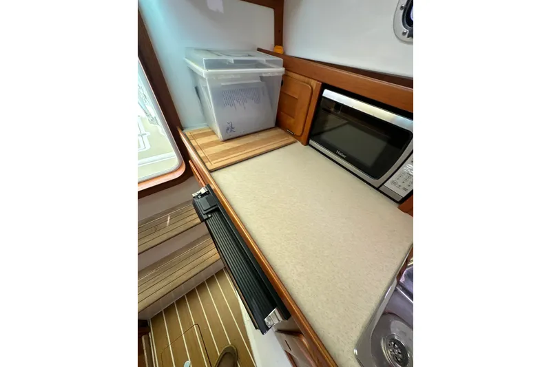 Slide: The Image of Interior of 2012 Hunt Yachts Surfhunter 29, featuring a compact kitchen area. - 17