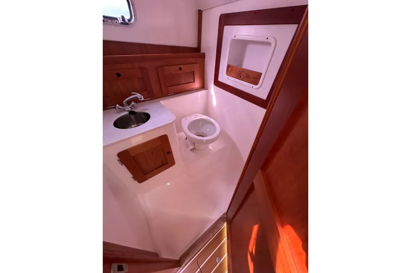 Slide: The Image of 2012 Hunt Yachts Surfhunter 29 bathroom with sink, toilet, and wooden cabinetry. - 15