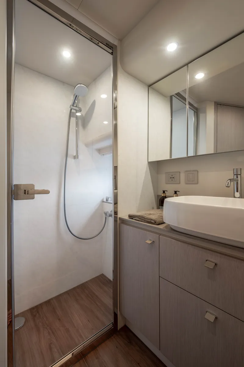 Slide: The Image of The image shows a modern yacht bathroom with a shower, sink, and wooden flooring. - 16