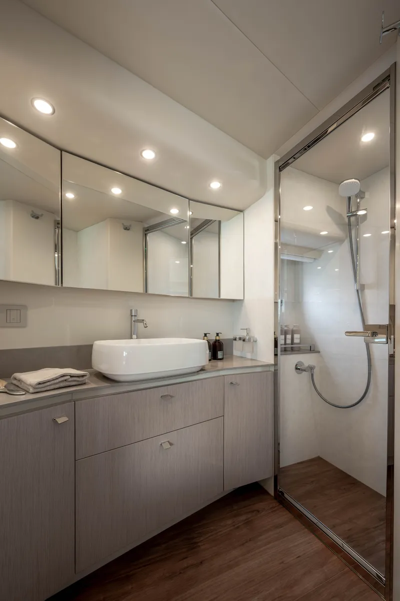 Slide: The Image of Modern bathroom with mirrors, sink, and glass-enclosed shower on a yacht. - 13