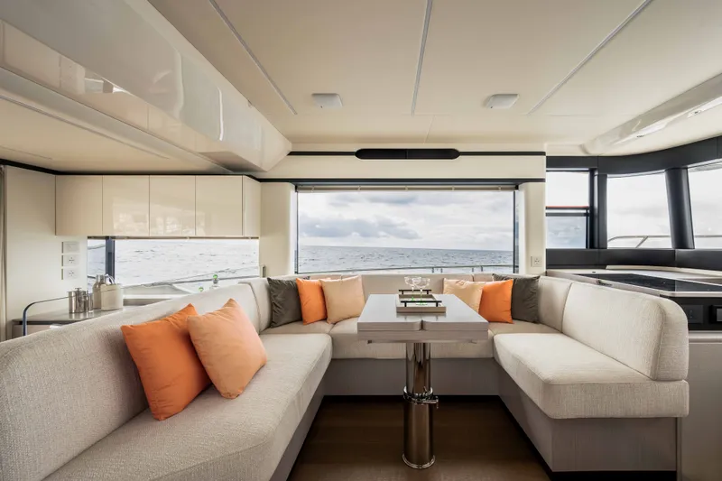 Slide: The Image of The interior of the 2028 Absolute Navetta 50 features an elegant seating area with orange cushions and a table. - 10