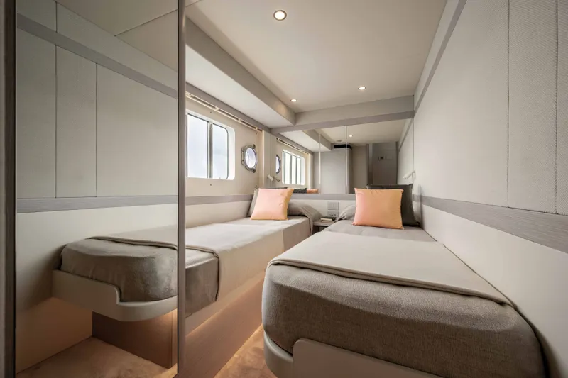 Slide: The Image of The 2028 Absolute Navetta 50 cabin features two single beds with elegant, modern decor. - 15