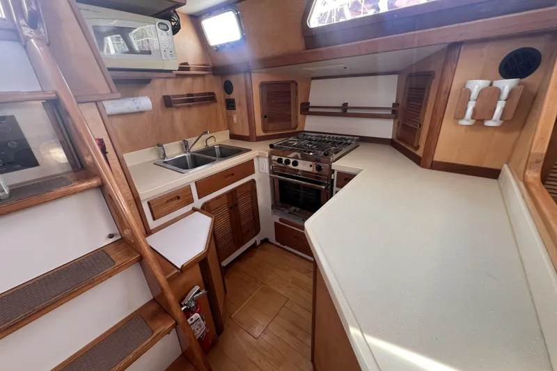 Slide: The Image of Compact kitchen in a 1991 Perry 51 yacht with stove, sink, and microwave. - 56