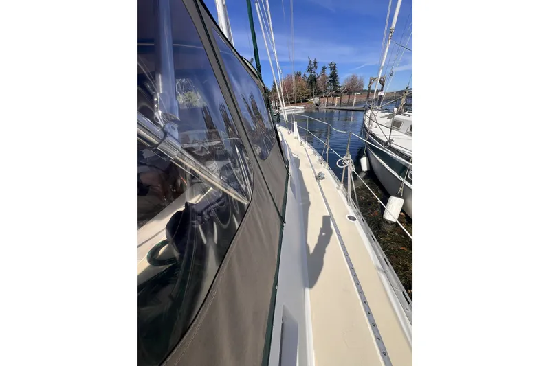 Slide: The Image of 1991 Perry 51 sailboat docked, showcasing deck and cabin details under clear blue sky. - 18