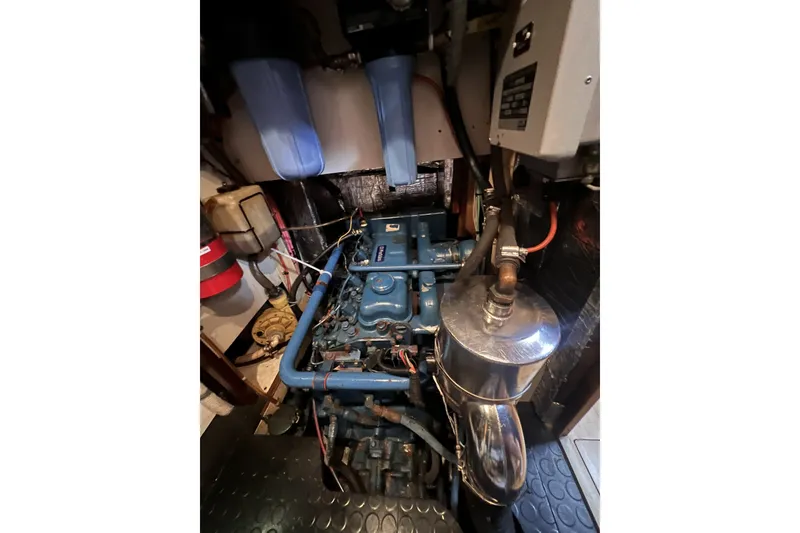 Slide: The Image of Engine room of a 1991 Perry 51, featuring a blue engine and filtration system. - 97