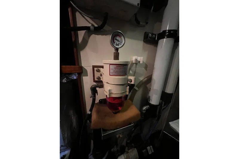 Slide: The Image of Fuel filter system in a 1991 Perry 51 engine room, featuring pressure gauge and piping. - 102