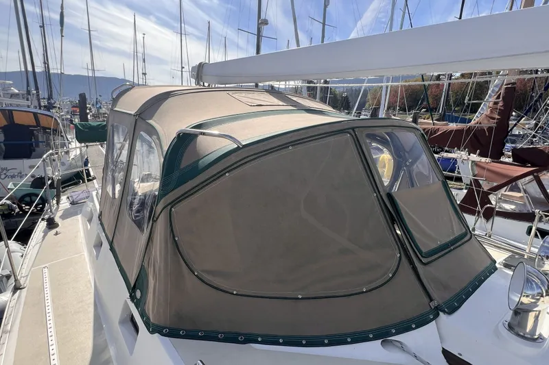 Slide: The Image of Sailboat with tan canvas cover, Perry 51 model, 1991, docked in marina. - 27