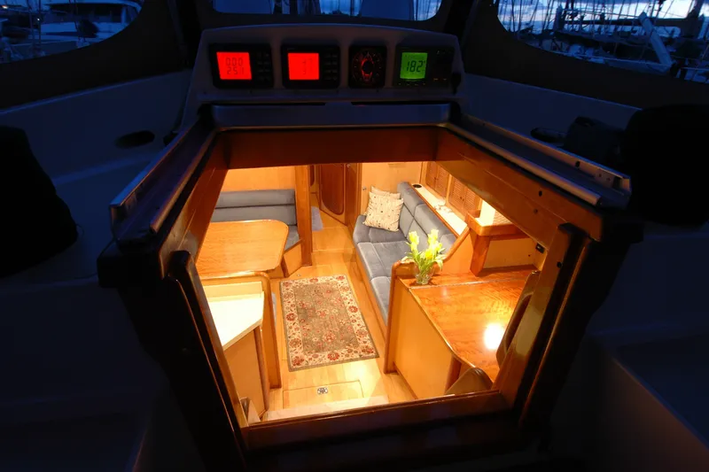 Slide: The Image of Interior view of a 1991 Perry 51 yacht, featuring cozy seating and warm lighting. - 52