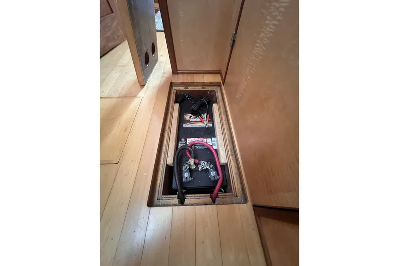 Slide: The Image of Battery compartment in 1991 Perry 51 boat with wooden flooring. - 113
