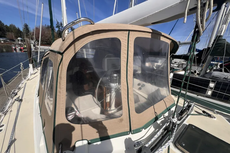 Slide: The Image of Sailboat Perry 51, 1991 model, with beige cockpit enclosure docked at marina. - 23
