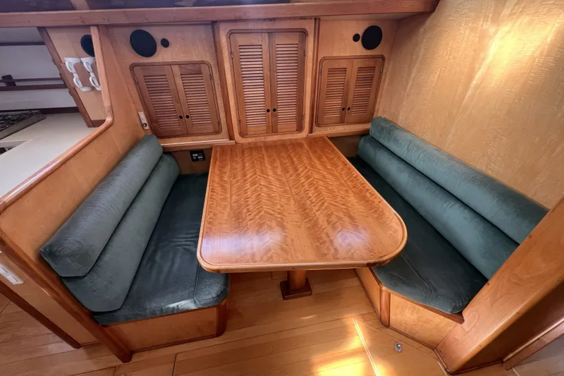 Slide: The Image of Cozy wooden dining area in a 1991 Perry 51 yacht with cushioned seating. - 63