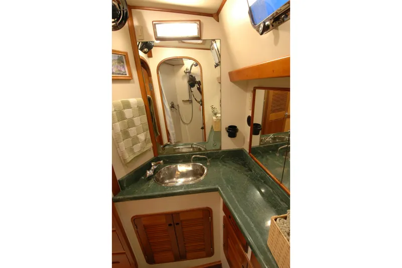 Slide: The Image of Luxurious bathroom in 1991 Perry 51 yacht with green marble countertop and stainless steel sink. - 84