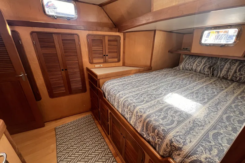 Slide: The Image of Cozy cabin interior of 1991 Perry 51 yacht with wooden furnishings and patterned bedding. - 78