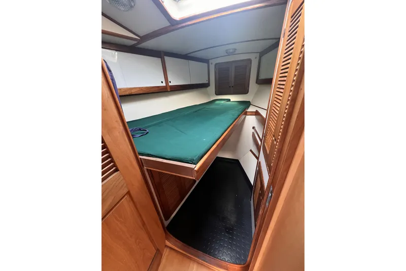 Slide: The Image of Cozy cabin interior of 1991 Perry 51 yacht with green bedding and wooden accents. - 88