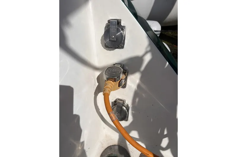 Slide: The Image of Power connection on a 1991 Perry 51 boat with orange cable plugged in. - 50