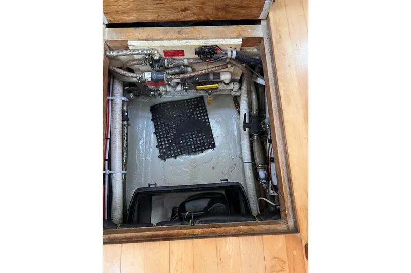 Slide: The Image of Bilge compartment of a 1991 Perry 51 boat, showing pipes and equipment. - 108