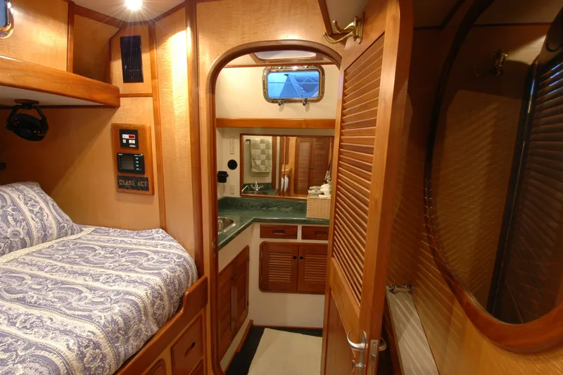 Slide: The Image of Cozy 1991 Perry 51 yacht cabin with bed, wooden interior, and compact bathroom. - 79